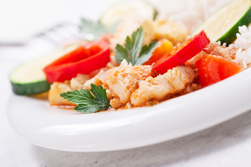 Homemade stewed fish with vegetables and rice, closeup, selective focus.