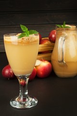Fresh pressed apple juice unfiltered. Apple juice and apples on wooden table. A healthy juice for athletes. Autumn apple harvest.
