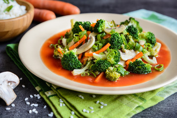 Vegetarian steamed broccoli salad with mushroom, carrot and onion, served with tomato sauce and rice
