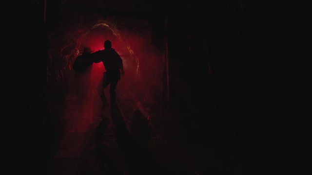 Silhouette of two men escaping a dark mine