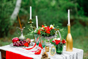 Wedding decor with fruit, flowers, candles  on a table in style of a boho-chic. Decoration of a wedding photoshoot.  Details of a wedding decor.