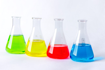 Four laboratory flasks with colorful liquids