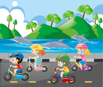 Children riding bike along the ocean