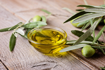 Olive oil and  branches on a wooden rustic background