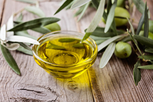 Olive oil and  branches on a wooden rustic background