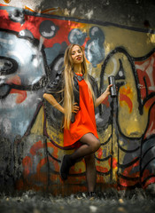 beautiful girl with long hair in a red dress on  background of graffiti