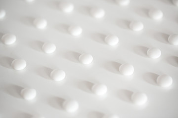 Fototapeta na wymiar White pills on a white top view.