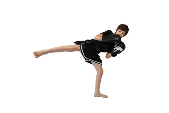 Teenage Asian boy in boxing gloves kicks isolated on white background