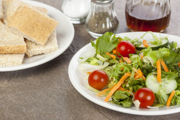 Plated salad and a plate of bread squares