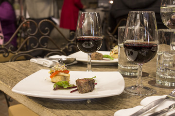 Wine glasses with napkins, glasses and gourmet food, banquet table. 
