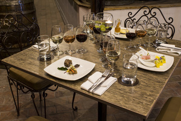 Wine glasses with napkins, glasses and gourmet food, banquet table. 