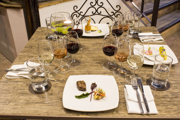 Wine glasses with napkins, glasses and gourmet food, banquet table. 