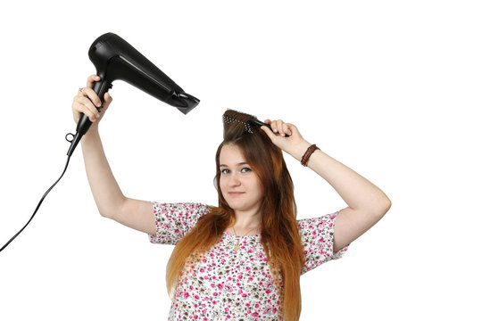 Pretty young girl dries hair by hairdryer isolated on white background - youth make up and beauty