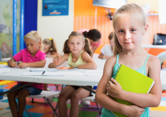 Schoolgirl with notepad in elementary school class indoors