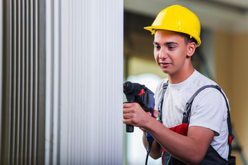 Man drilling the wall with drill perforator