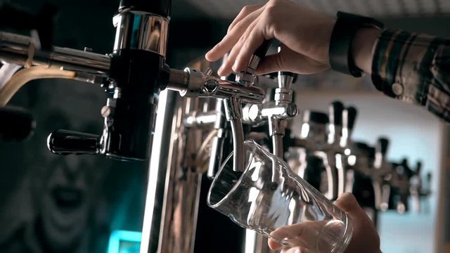 Beer into glass with a lot of bubles and foam super close up slow motion.