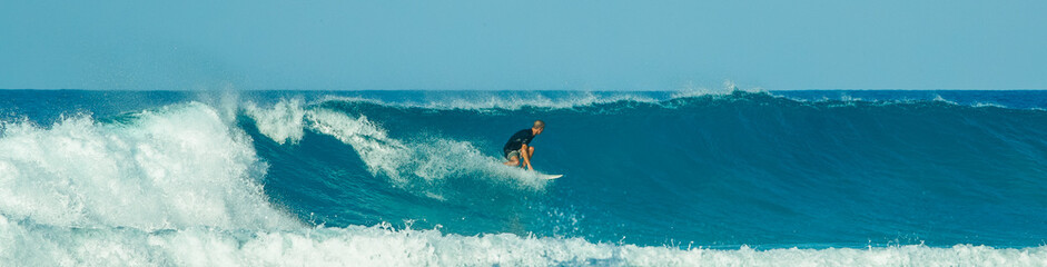 surfer in blue waves in the caribbean - obrazy, fototapety, plakaty
