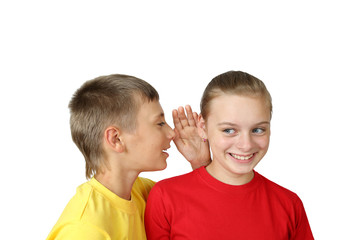 Rumors - teenage boy in yellow tells funny secret to smiling girl in red t-shirt isolated on white background