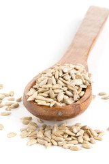 Natural shelled sunflower seeds in wooden spoon over white background