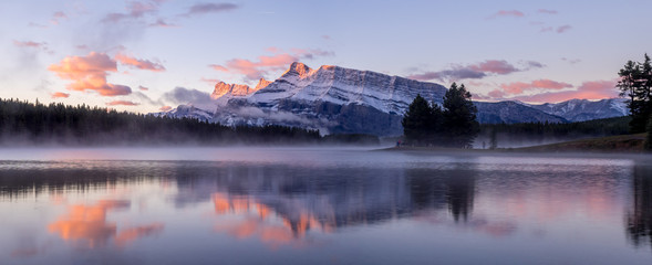 Rundle Mountain reflecting in Two Jack Lake in Banff National Park at sunrise. 