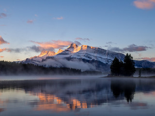 Rundle Mountain reflecting in Two Jack Lake in Banff National Park at sunrise. 