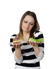 Diet, nutrition, weight loss and choice concept - Young woman chooses between cake and lettuce isolated on white background