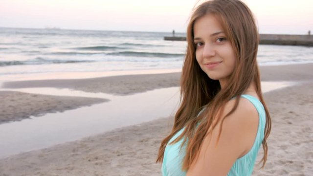 Beautiful girl stays at the beach near sea
