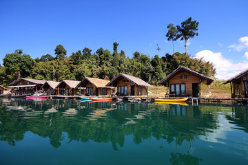Fototapeta na wymiar Beautiful scenery of houseboat and the beautiful water reflection with clear sky at lake river in natural attractions,Ratchaprapha Dam at Khao Sok National Park,Surat Thani Province in Thailand.