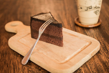 Close up Slice of chocolate cake with cup of coffee on wood table.