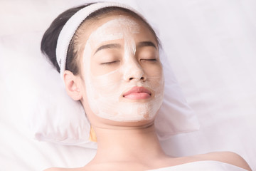 Fototapeta na wymiar Young girl with facial mask at beauty salon