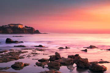 Castiglioncello old building on the rocks and sea on sunset. Tus