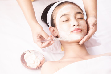 Young girl with facial mask at beauty salon