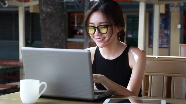 Portrait of thai adult student university beautiful girl using her laptop.