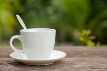 Coffee cup with coffee stains edge on wooden in the backyard Nat