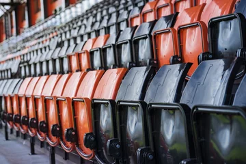 Keuken foto achterwand Stadion Rijen met zwarte en rode plastic stadionstoelen, scherptediepte conc