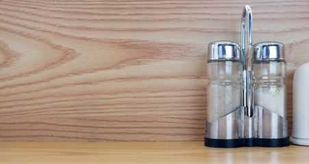 salt and pepper shaker on yellow wood table with copy space