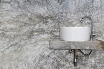 white basin and chrome on gray lolf concrete wall
