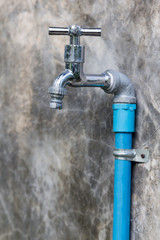 chrome faucet with blue pipe on wall