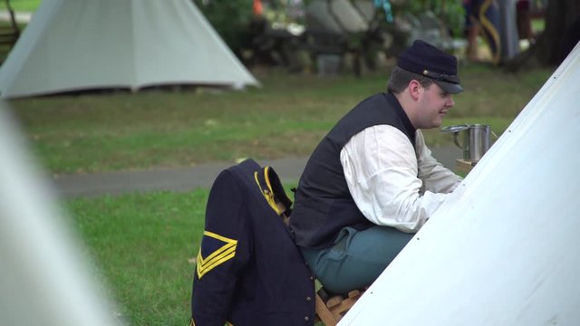 Civil War soldier chats near tent in camp