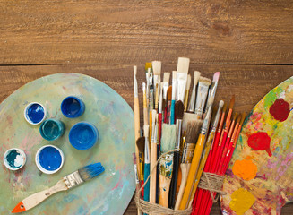 Fototapeta premium Paints, brushes and palette on the colorful background. The workplace of the artist. Banner for school