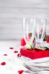 Elegant holiday table setting with red ribbon gift