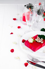 Elegant holiday table setting with red ribbon gift