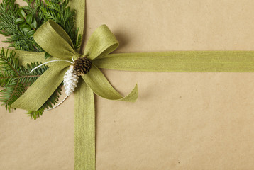 Christmas gift close up with bow and natural decorations. Christmas present wrapped in recycled...