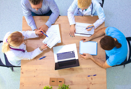 Male and female doctors working on reports in medical office