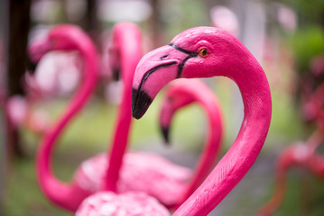 Close-up detail of a pink flamingo sculpture decorating a lawn, with a blurred out background. Home and garden decoration concept. - 122465599