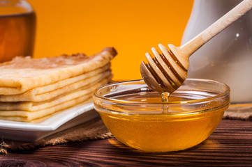 Fresh honey with a Stack of blinis or crepes