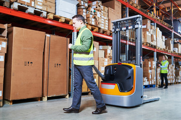 Warehouse Management System. Workers with barcode scanner and stacker