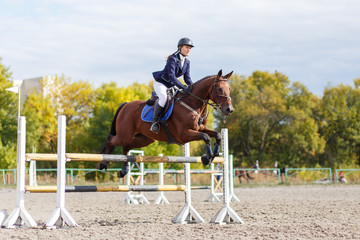 Young horse rider girl on equestrian competition