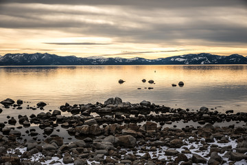 Heavy sky hanging over golden light lit magnificient Lake Tahoe