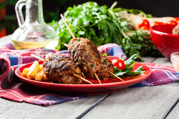 Barbecued kofta with fries on a plate